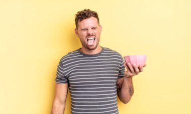 Neşeli ve asi tavırlı genç yakışıklı adam, şaka yapıyor ve boş kase kavramını dillendiriyor.