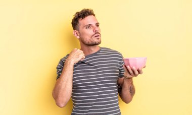 Genç yakışıklı adam stresli, endişeli, yorgun ve hayal kırıklığına uğramış boş kase konsepti