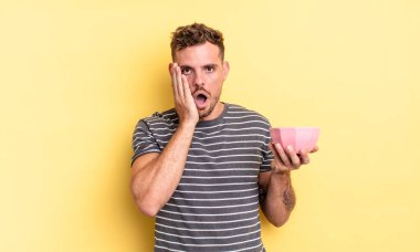 Genç yakışıklı adam şok olmuş ve korkmuş boş kase konsepti