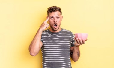 Genç yakışıklı adam şaşırmış görünüyor, yeni bir düşünce, fikir ya da konsept olarak boş kase kavramının farkına varıyor.