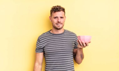 Kafası karışmış ve kafası karışmış genç yakışıklı bir adam.