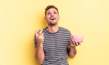 Genç yakışıklı adam umutsuz görünüyor, hayal kırıklığına uğramış ve stresli boş kase konsepti