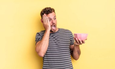 Genç yakışıklı adam mutlu, heyecanlı ve şaşırmış boş kase konsepti