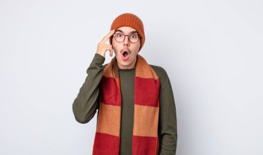 Genç yakışıklı adam şaşırmış görünüyor, yeni bir düşünce, fikir ya da konsept fark ediyor. Kışlık kıyafet konsepti