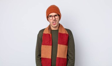 Genç yakışıklı adam şaşkın ve şaşkın hissediyor. Kışlık kıyafet konsepti