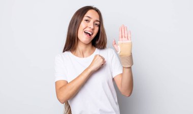 Genç ve güzel bir kadın kendini mutlu hissediyor ve bir meydan okumayla yüzleşiyor ya da kutluyor. el bandajı konsepti