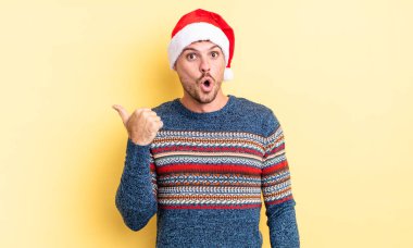 İnanamadığı için şaşırmış genç ve yakışıklı bir adam. Noel konsepti
