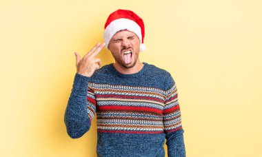 Genç yakışıklı adam mutsuz ve stresli görünüyor, intihar jesti silah işareti yapıyor. Noel konsepti