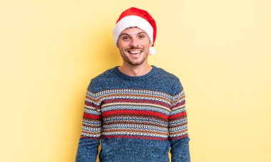 Genç yakışıklı adam mutlu ve hoş bir şekilde şaşırmış görünüyor. Noel konsepti