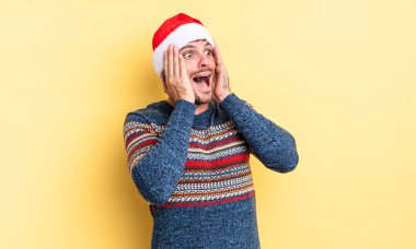 Genç yakışıklı adam mutlu, heyecanlı ve şaşırmış hissediyor. Noel konsepti