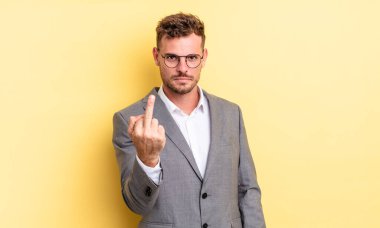 young handsome man feeling angry, annoyed, rebellious and aggressive. business concept