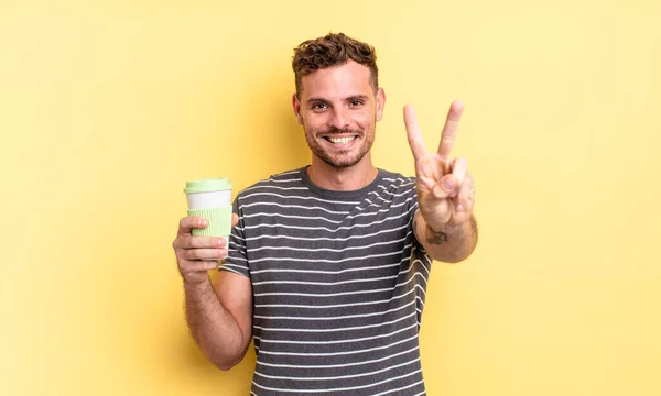 Jovem Homem Bonito Sorrindo Olhando Feliz Gesticulando Vitória Paz Tirar — Fotografia de Stock