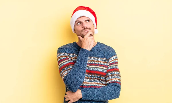 若いハンサムな男は 疑問と混乱を感じて考えている クリスマスのコンセプト — ストック写真
