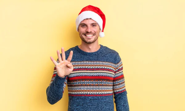 若いハンサムな男は笑顔で友好的に見える4番目を示しています クリスマスのコンセプト — ストック写真