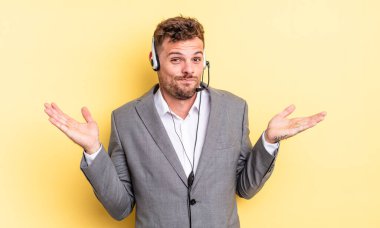 Genç yakışıklı adam şaşkın, şaşkın ve şüpheci hissediyor. Tele-pazarlamacı ortak.