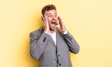 Genç yakışıklı adam mutlu, heyecanlı ve şaşırmış hissediyor. Tele-pazarlamacı ortak.