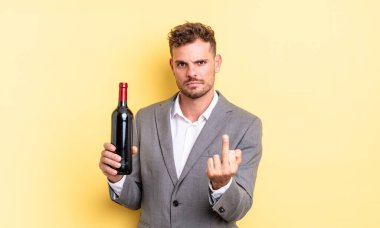 Genç ve yakışıklı bir adam sinirli, sinirli, asi ve agresif hissediyor. Şarap şişesi konsepti