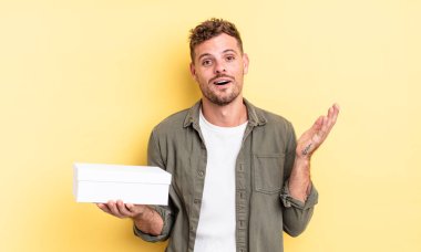 Genç yakışıklı adam kendini mutlu hissediyor, bir çözüm ya da fikir bulduğuna şaşırıyor. beyaz kutu kavramı