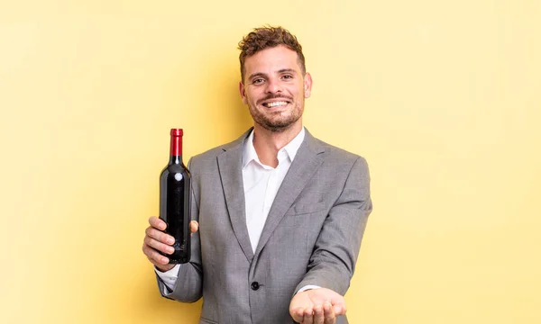 Genç Yakışıklı Bir Adam Arkadaşça Gülümsüyor Bir Konsept Sunuyor Şarap — Stok fotoğraf