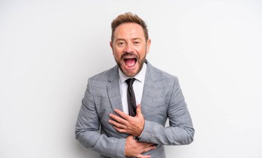 Orta yaşlı yakışıklı bir adam komik bir şakaya yüksek sesle gülüyor. İş adamı konsepti