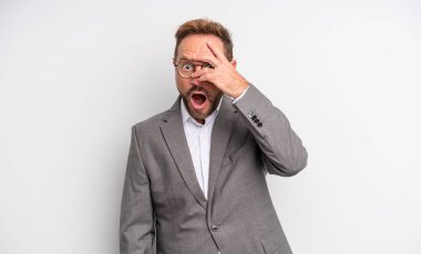 Orta yaşlı yakışıklı bir adam şok olmuş, korkmuş ya da korkmuş görünüyor. Yüzü elle kapatılmış. İş adamı konsepti