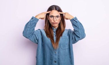 Ciddi ve konsantre bakışlı, beyin fırtınası yapan ve zorlu bir sorunu düşünen güzel İspanyol bir kadın.