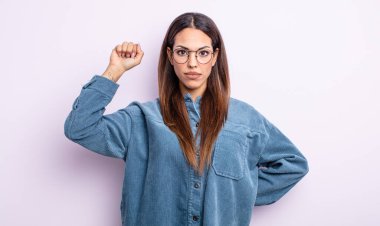 İspanyol bir kadın ciddi, güçlü ve isyankar hissediyor, yumruğunu kaldırıyor, protesto ediyor ya da devrim için savaşıyor.