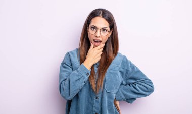 Ağzı ve gözleri sonuna kadar açık, eli çenesinde, hoş olmayan bir şekilde şokta olan, ne ya da vay canına diyen İspanyol bir kadın.