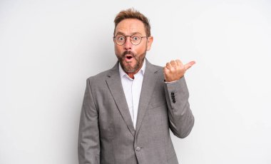 Orta yaşlı yakışıklı bir adam inançsızlıktan şaşkın şaşkın bakıyor. İş adamı konsepti