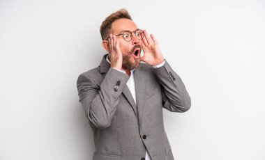 Orta yaşlı yakışıklı adam mutlu, heyecanlı ve şaşırmış hissediyor. İş adamı konsepti