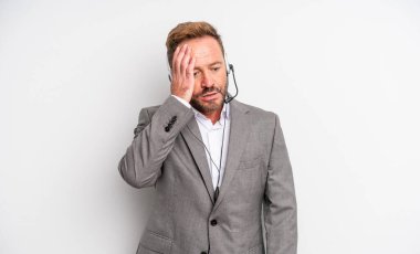 Orta yaşlı yakışıklı bir adam bıkkın, yorgun ve uykulu hissediyor. tele pazarlama kavramı