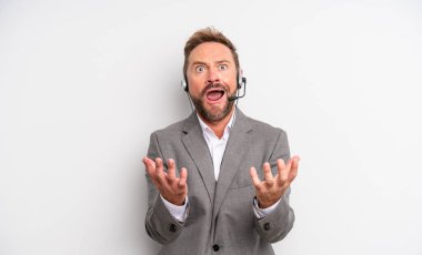 Orta yaşlı yakışıklı adam umutsuz, sinirli ve stresli görünüyor. tele pazarlama kavramı