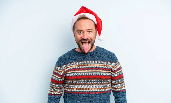 陽気で反抗的な態度を持つ中年のハンサムな男冗談と舌を突き出す クリスマスのコンセプト — ストック写真
