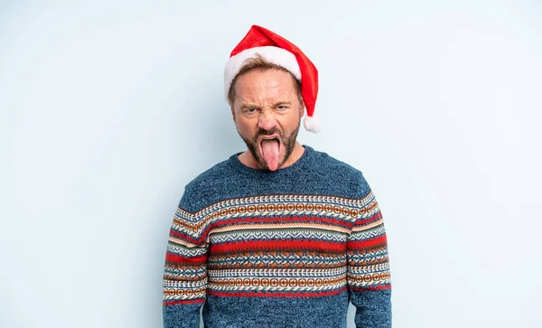 中年のハンサムな男はうんざりしていらいらして舌を出す感じ クリスマスのコンセプト — ストック写真
