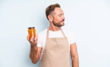 Profil görünümlü orta yaşlı yakışıklı bir adam hayal kuruyor ya da hayal kuruyor. şeftali reçeli konsepti