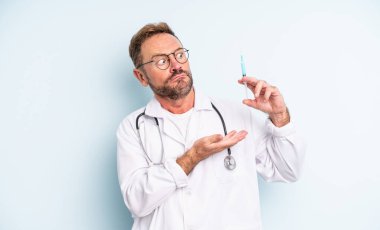 Orta yaşlı yakışıklı adam omuz silkiyor, kafası karışık ve kararsız. srynge konsepti