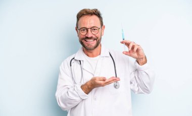 Orta yaşlı yakışıklı adam neşeli bir şekilde gülümsüyor, mutlu hissediyor ve bir konsept gösteriyor. srynge konsepti