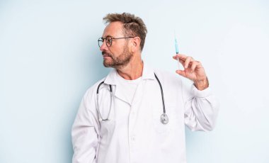 Profil görünümlü orta yaşlı yakışıklı bir adam hayal kuruyor ya da hayal kuruyor. srynge konsepti