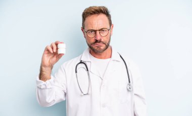 Orta yaşlı, yakışıklı, üzgün ve mızmız, mutsuz bakışlı ve ağlayan bir adam. İlaç şişesi olan doktor.