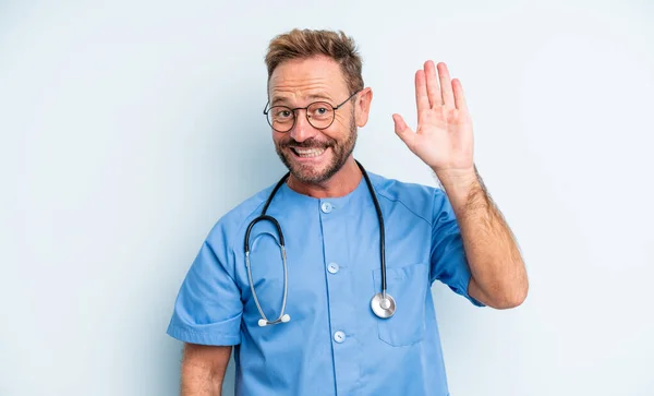 中年のハンサムな男が喜んで手を振って歓迎し挨拶する 看護師の概念 — ストック写真