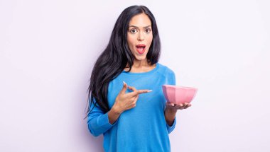 Güzel İspanyol bir kadın heyecanlı ve şaşırmış görünüyor. boş kase kavramı