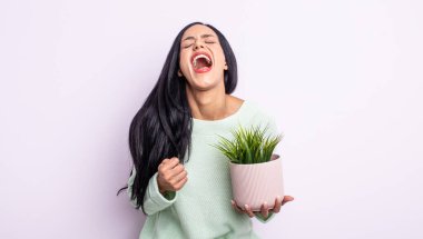 Oldukça İspanyol bir kadın agresif bir şekilde bağırıyor, çok kızgın görünüyor. ev bitkisi konsepti