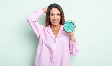 Oldukça İspanyol bir kadın stresli, endişeli ya da korkmuş, elleri başının üstünde. Alarm saati kavramı
