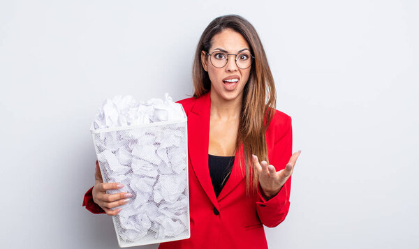 pretty hispanic woman looking angry, annoyed and frustrated. paper balls failure concept