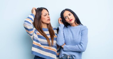 Kafası karışık, kafası karışık, kaşınan bir İspanyol kadın. bir çift arkadaş kavramı