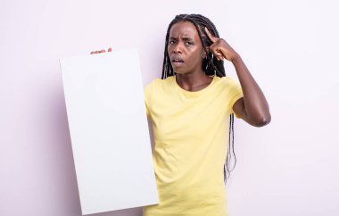 Güzel siyah kadın kafası karışık ve şaşkın hissediyor, deli olduğunu gösteriyor. boş tuval konsepti