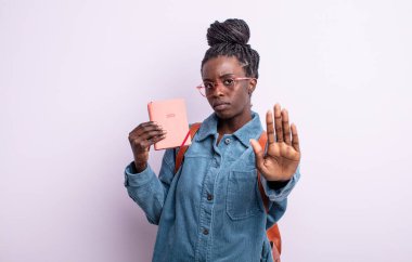 Güzel siyahi kadın ciddi görünüyor. Avuç içi gösteriyor. Durma hareketi yapıyor. ajanda kavramı