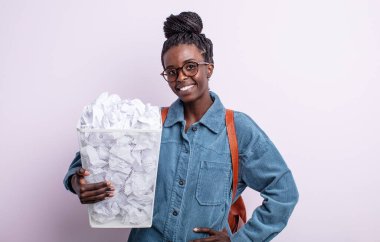 Güzel siyah kadın mutlu bir şekilde gülümsüyor, eli kalçasında ve kendinden emin. kağıt toplar başarısızlık konsepti