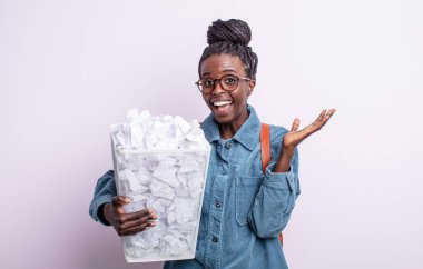 Güzel siyah bir kadın inanılmaz bir şey karşısında mutlu ve şaşkın hissediyor. kağıt toplar başarısızlık konsepti