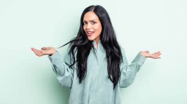 Güzel İspanyol kadın şaşkın ve kafası karışık, şüpheci, farklı seçenekleri tartıyor ya da komik bir ifadeyle seçiyor.